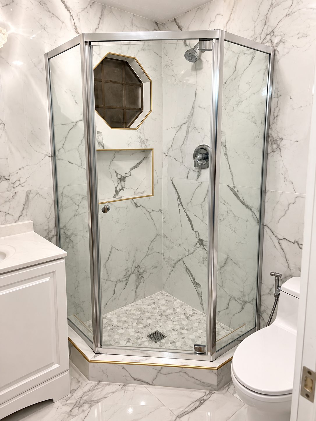 Corner shower with marble slab walls and brass trim
