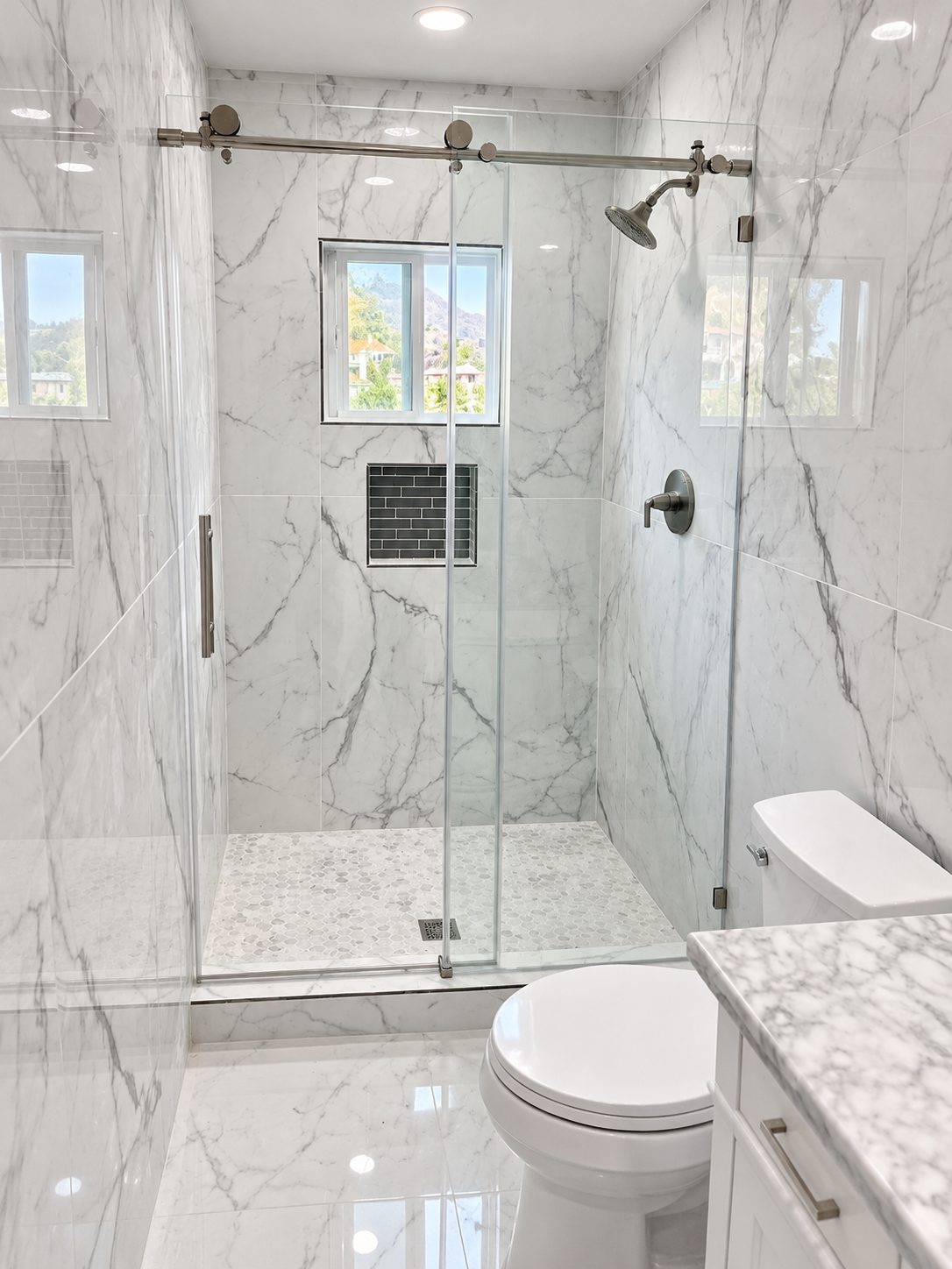 White marble slab walk-in shower with hillside window