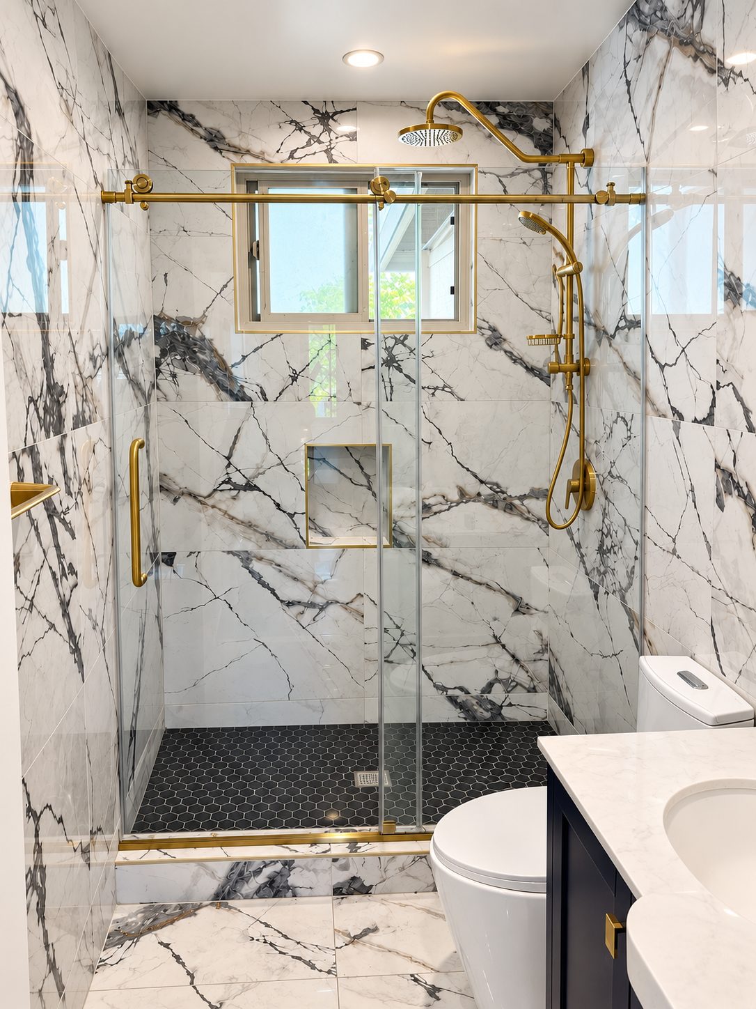 Marble shower with brass rain shower and black hexagon tile floor, remodeled by WeFiks