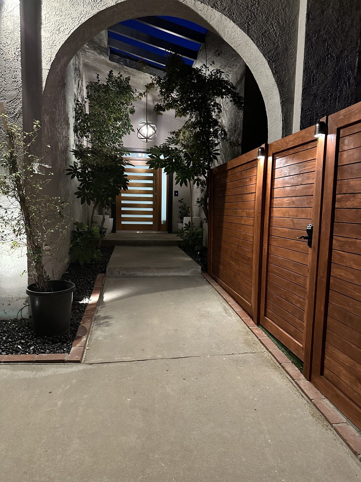 Stained horizontal gate at the entry walkway, lit at night