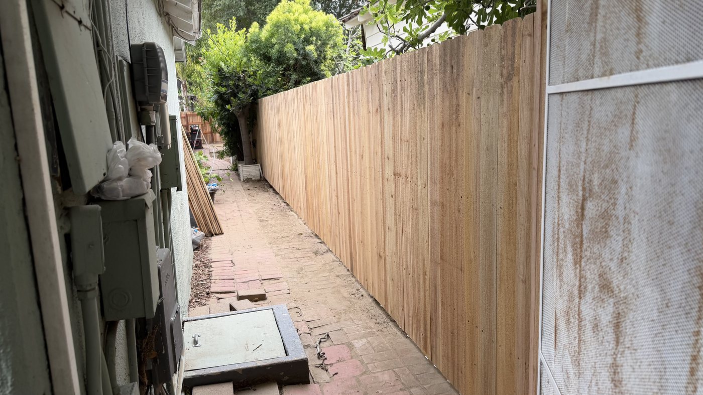 Vertical cedar privacy fence along a narrow side yard